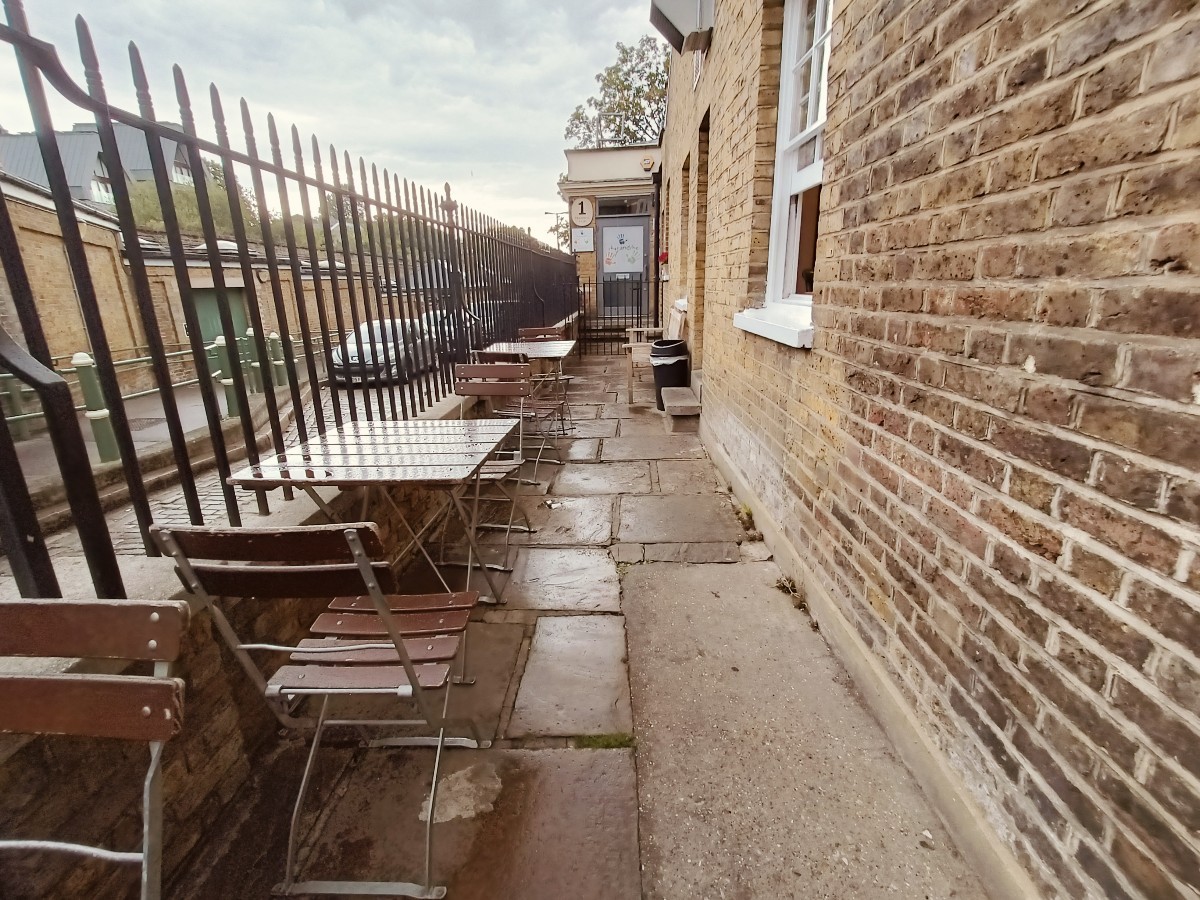 From end of right tables and chairs, facing straight. Tables and chairs along left.