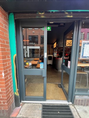 Glass double doors with grey frame. Push grey handle at centre of doors to open.