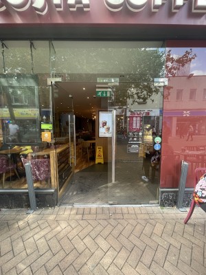 Glass doors ahead. Push silver metal handle from centre to open.