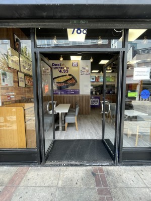 Glass doors with black frame ahead. Push silver metal handles from centre to open.
