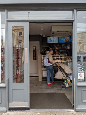 Glass doors with blue frame and silver handles. Push from centre to open.