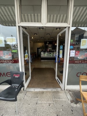 Glass doors with white frame ahead. Push blue handles from centre to open.