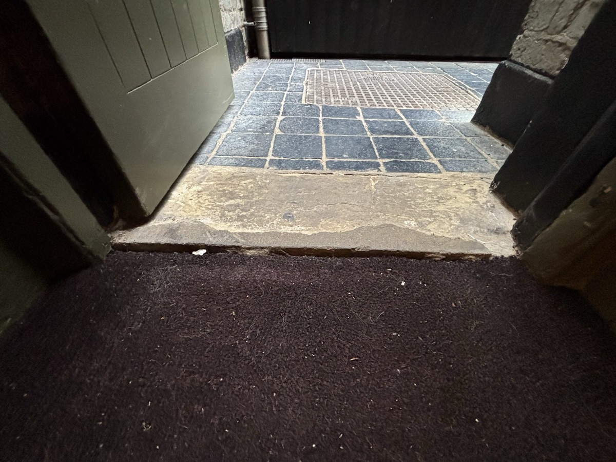 Doormat before door, followed by small bump at foot of door.