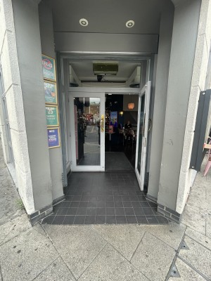 Glass doors with white frame ahead. Pull gold metal handles from centre to open.