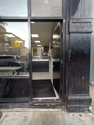 Black, wooden door ahead. Push from left to open.