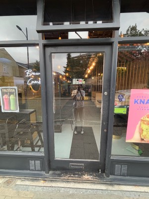 Glass doors with grey frame ahead. Push from right to open.