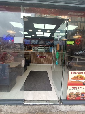 Glass door with silver handle on left. Push to open.