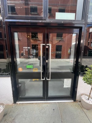 Glass doors with black, frame. Pull silver handles in middle to open.