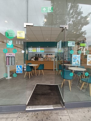 Glass door with silver handle on left. Push to open.