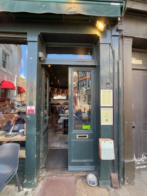 Glass doors with dark green frame ahead. Push from center to open.