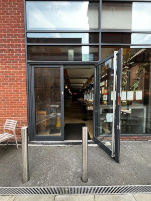 Glass double doors with black frame and silver handle. Pull handle at centre of door to open.