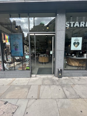 Glass door ahead with long handle along right. Push to open.