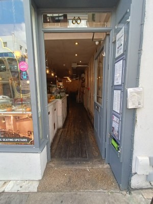 Glass door with grey, wooden frame ahead. Push from left to open.