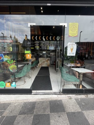 Glass door ahead. Push silver metal handle from left to open.