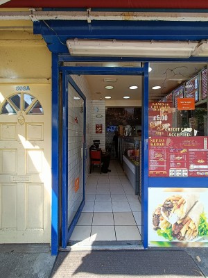 Glass door with blue, metal frame. Push from right to open.