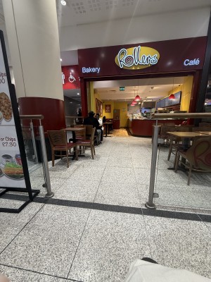 Fixed restaurant barriers on left and right. Retail area straight. Tables and chairs on left and right.