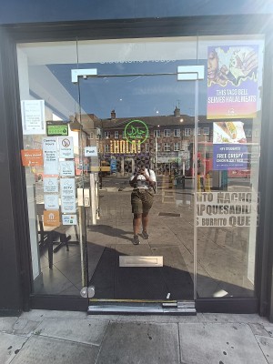 Glass door with silver handle on left. Push to open.
