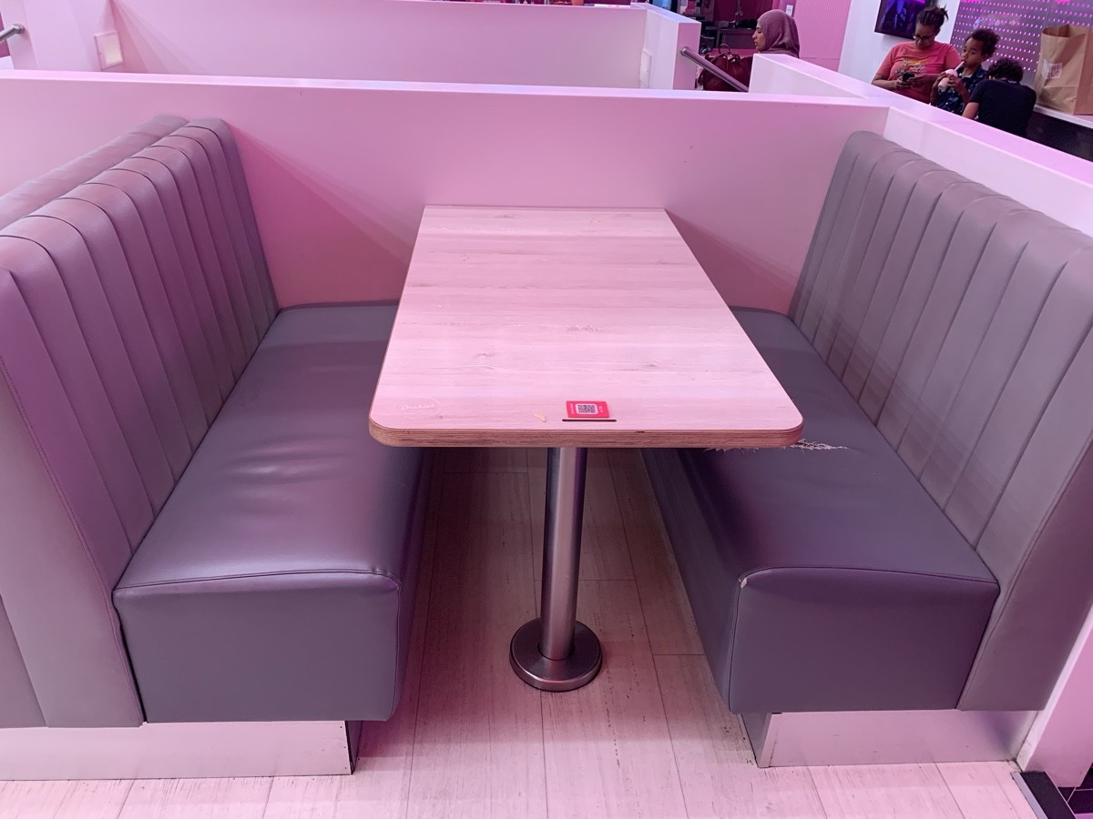 From stairs facing left. Booth and table ahead.