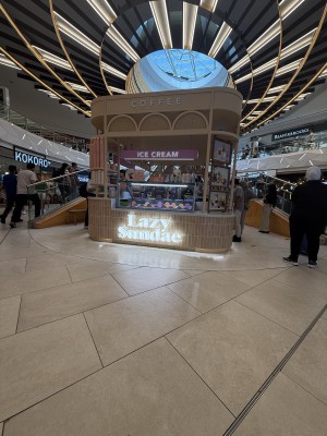 Open entrance. Counter in centre. Ordering station on right. Waiting area on left.