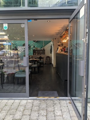 Glass doors with grey frame and grey handles. Pull from centre to open.