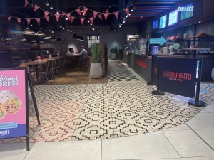 From main entrance facing straight. Seating area to the left. Counter to the right. Wall at the back.