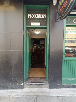 From right side of venue, facing left. Green wooden door ahead. Push from right to open.