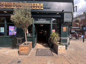 Facing entrance. Path straight to doors, push from centre to open with silver handles. Planters to the left and right before entrance.