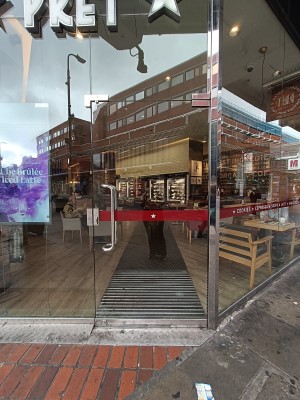 Glass door with silver handle on left. Push to open.