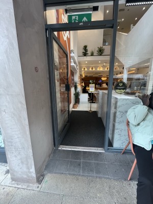 Grey framed glass door. Push grey handle on right to open.
