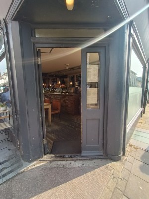 Glass door with grey wooden door ahead. Push from right to open.