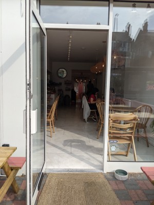Glass door with white frame. Pull from white handle on left to open.