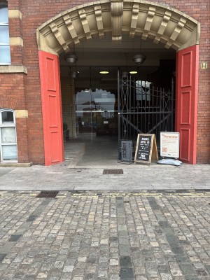 From street side facing entrance. Archway through to the entrance path.