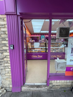 Glass door with purple frame. Push from silver handle on right to open.
