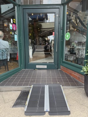 Green glass door. Metal handle to pull on left.