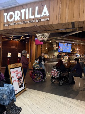 Open entrance with level floor and no obstructions. Kiosks are on the left to order food, with food receiving stations immediately ahead.