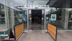 Glass automatic doors. Doors slide from centre to open. Wooden dividers on each side before entrance.