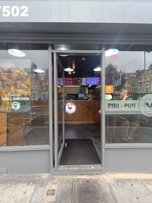 Glass door with grey, metal frame. Push grey handle on right to open.