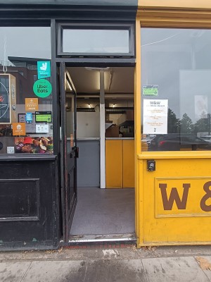 Glass door with black, wooden frame. Push from right to open.