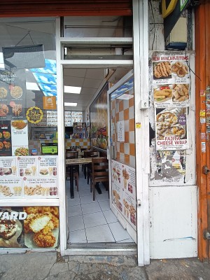 Glass door with white, wooden frame ahead. Push from left to open.