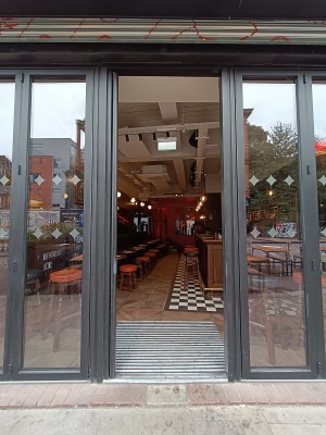 Glass doors with grey, metal frame. Silver handle on right to open.