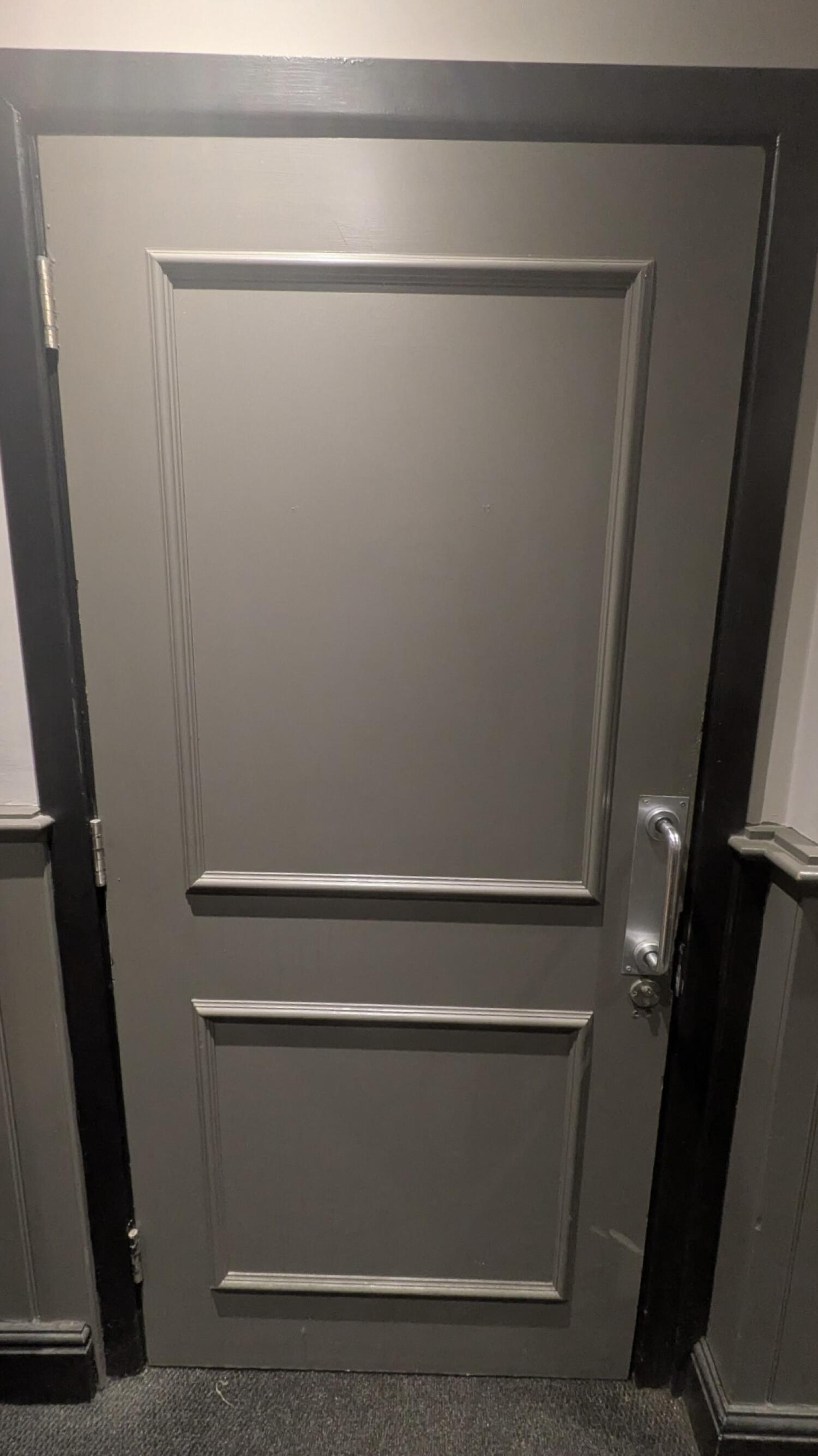 From second doorway facing right. Door to accessible toilet. Pull metal handle on right to open.