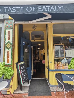 Glass door with blue wooden frame. Pull from right to open. A frame on the left slightly obstructing path.