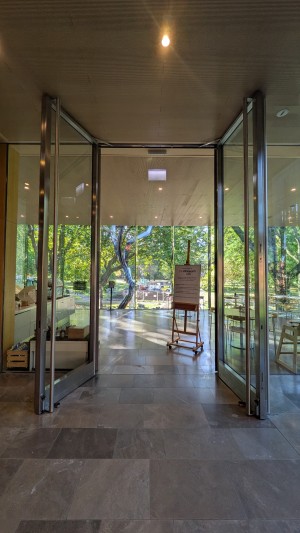 Glass doors with metal frame. Pull metal handles in center to open.