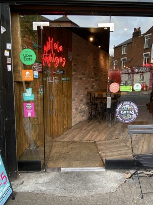 Glass door with metal handle on right. Push to open.