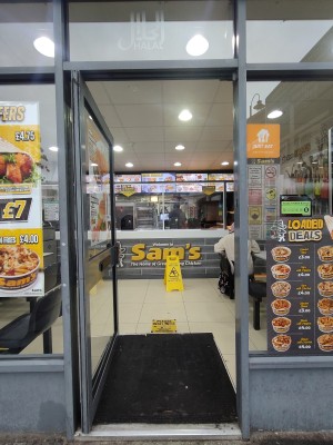 Glass door with metal frame. Push metal handle on right to open.