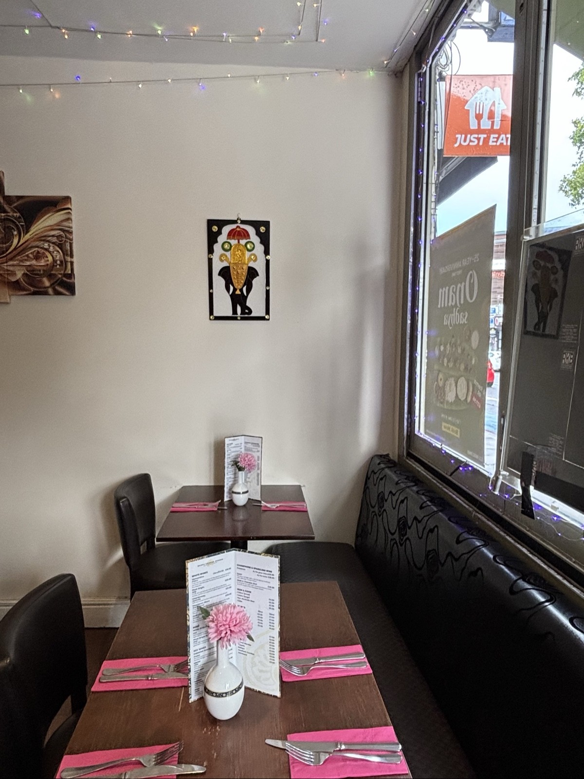 From entrance facing right. Half booth, tables and chairs below window. Decorations on back wall