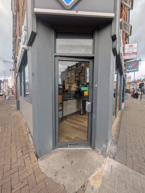 Grey frame door with handle on right. Push to open. Raised edge at entrance.