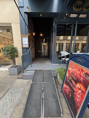 From sidewalk facing venue entrance. Ramp leading to entrance.