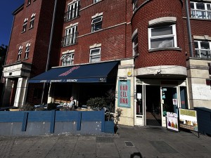 From side walk facing venue. Main entrance door on left, outside seating area on the left.