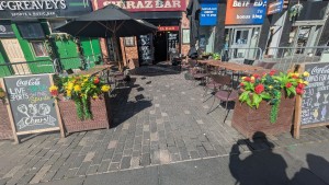 From street facing venue. Planters and boards to both sides. Path to door in center.